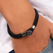 Bracciale in Acciaio in corda di tessuto nero e chiusura centrale lavorata a fantasia floreale in smalto nero.