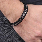 Bracciale in Acciaio rigido in pelle nera intrecciata con una catena in metallo lucido. Chiusura a scomparsa