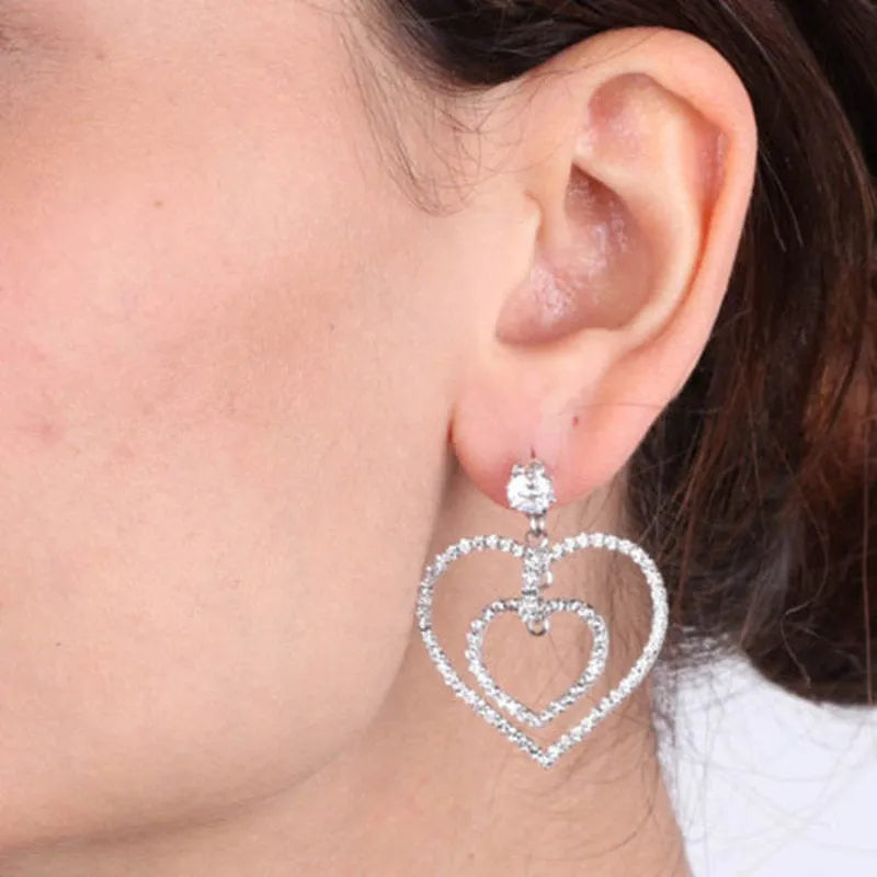 Metal dangle earrings with a double heart embellished with crystals