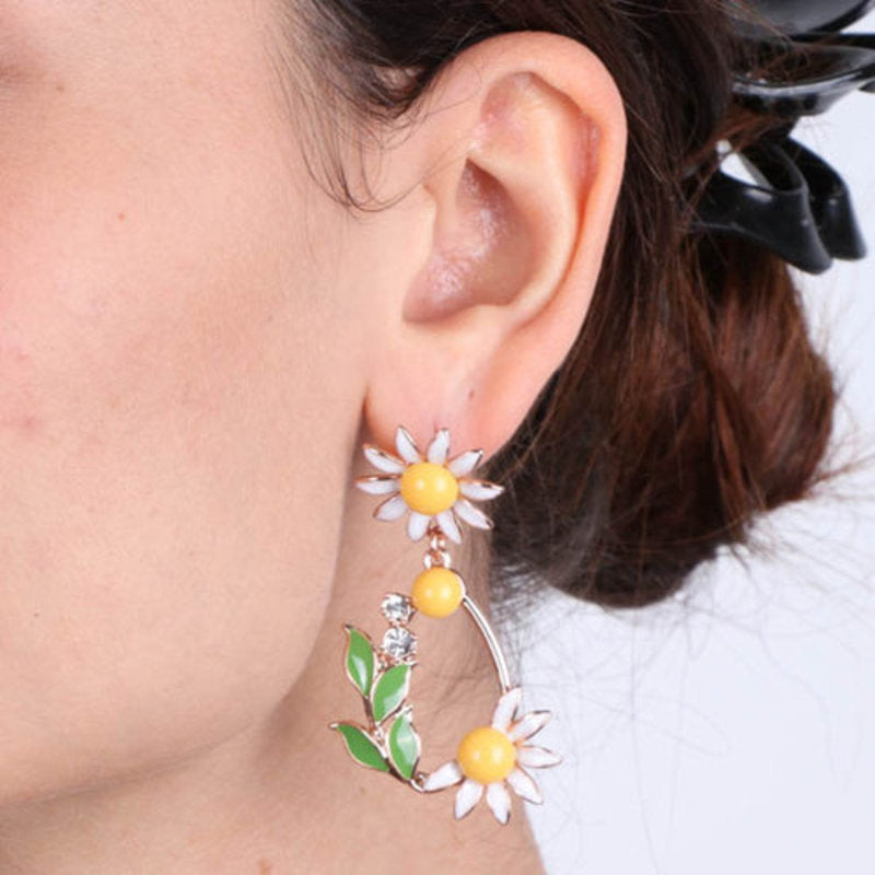 Metal Earrings with dangling daisies embellished with colored enamel and white crystals