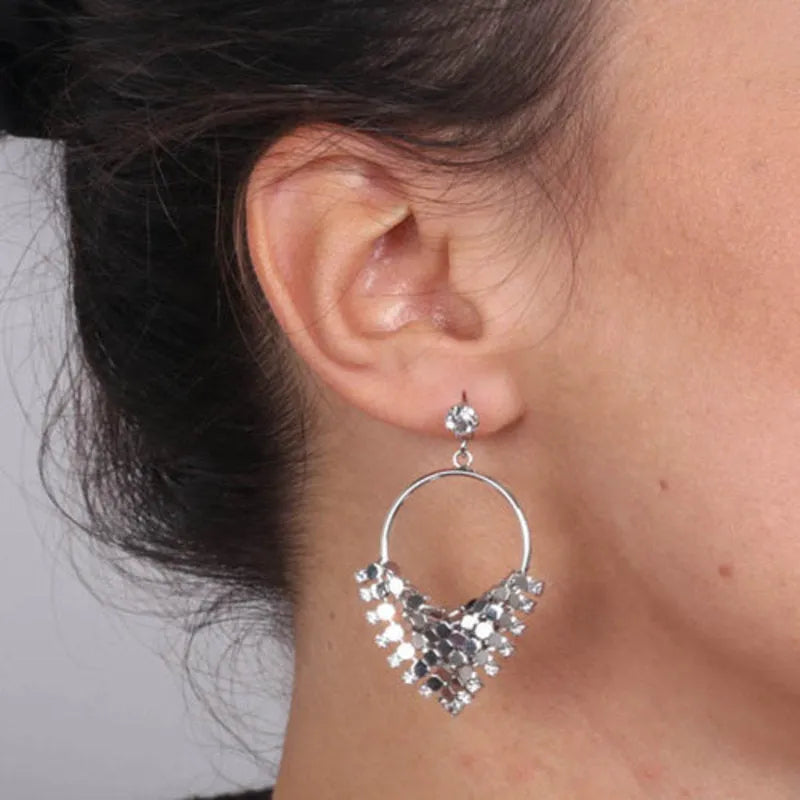 Hoop metal earrings with a dangling triangle embellished with luminous crystals