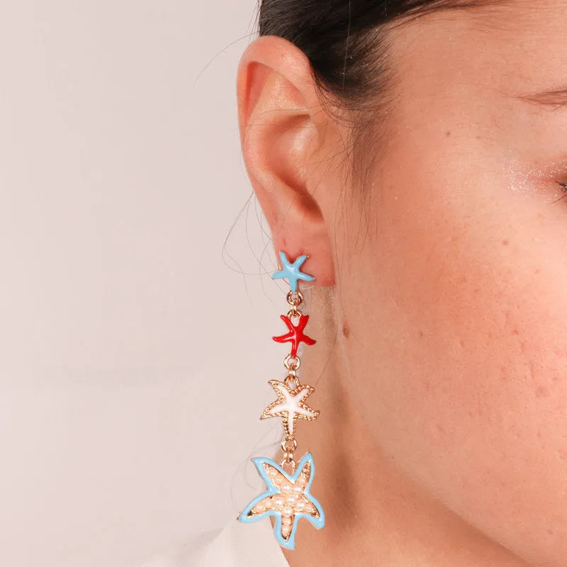 Metal earrings with hanging colored starfish