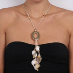 Collana in Metallo  lunga con corda e conchiglie pendenti e grande anello dorato centrale