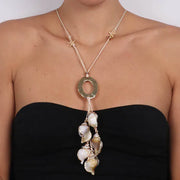 Collana in Metallo  lunga con corda e conchiglie pendenti e grande anello dorato centrale