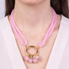 Multi-strand metal necklace with pink crystals and central circle