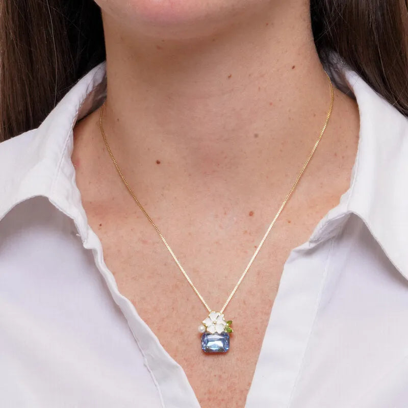 Necklace with white flower and light blue crystal in metal