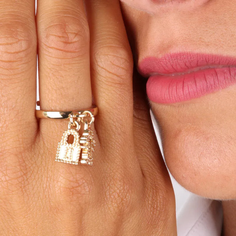 Metal ring with child-shaped pendants and padlock