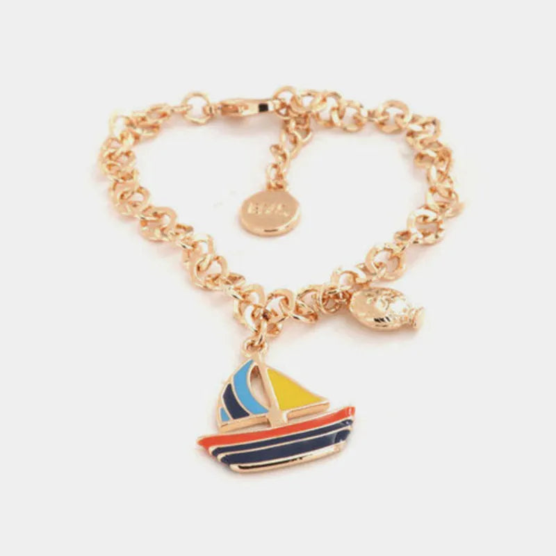 Metal bracelet with a dangling boat, embellished with colorful enamel and a mini pumo charm on the side