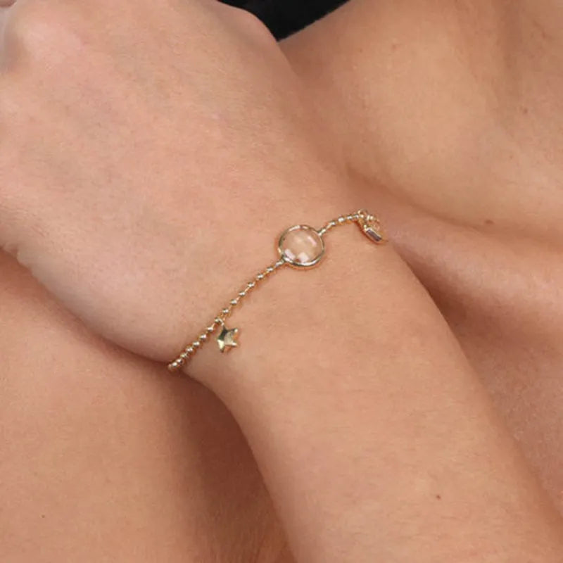 Metal bracelet with white crystal and charms