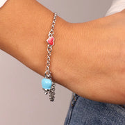 Bracciale in Metallo con cuore rosso e campanella portafortuna pendente, impreziosita da smalto azzurro e punto luce