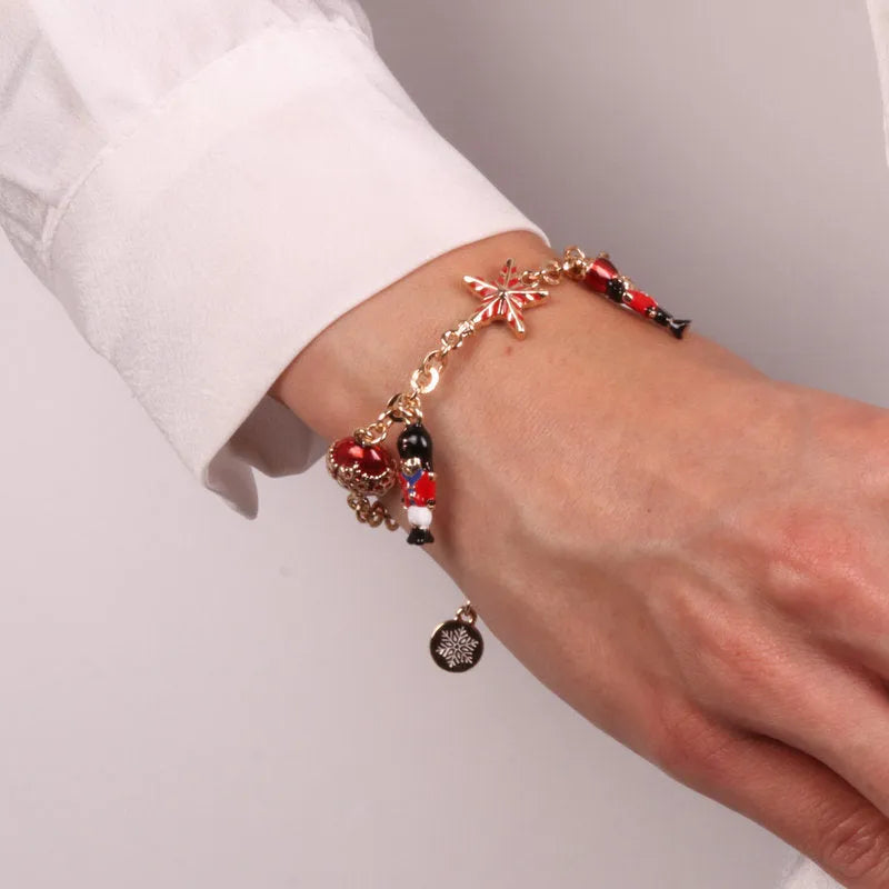 Metal bracelet with ball and nutcracker-shaped pendants