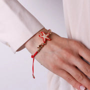 Bracciale in Metallo con cordino rosso e sfere con stella marina