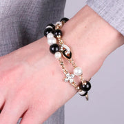 Bracciale in Metallo doppio filo con perle nere e bianco con croce zirconata