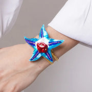 Bracciale in Metallo rigido, con stella marina smaltata turchese e pietre rosse
