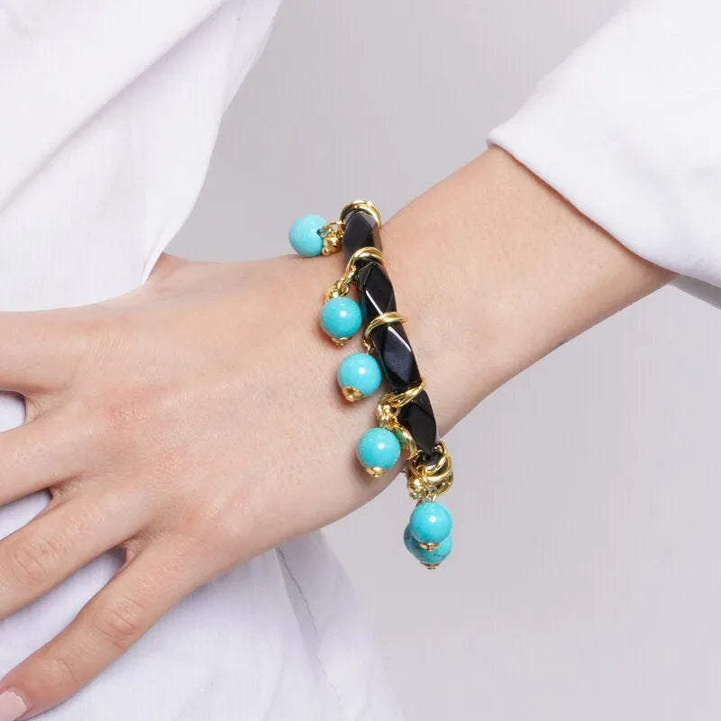 Metal bracelet with a circle of black crystals and dangling turquoise beads