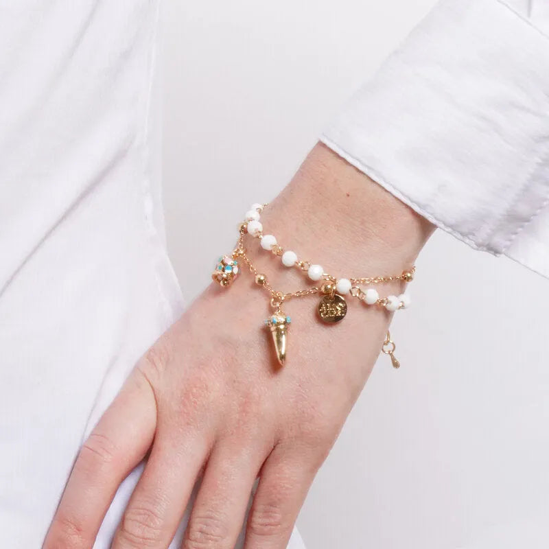 Bracciale in Metallo multifilo con sfere bianche, corno dorato con dettagli azzurri e campanella multicolore