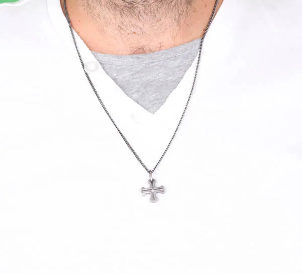 Collana in Acciaio con pendente raffigurante una croce greca impreziosita da cristalli neri.