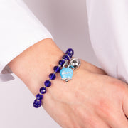 Metal bracelet with blue bell and small rattle with blue stones