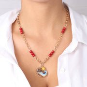 Collana in Metallo con pendente faraglioni, mare e sole e perline corallo rosso sulla catena