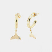 Orecchini in Argento 925 cerchietti con pinna di delfino pendente, arricchita da punto luce di cristalli bianchi.